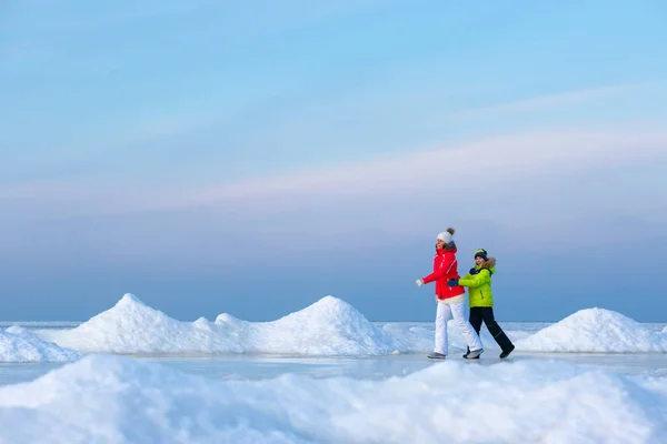 Ung mamma och hennes son på isiga beach — Stockfoto