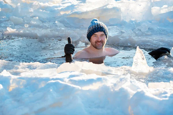 Zimní plavání. Odvážný muž v díře v ledu- — Stock fotografie