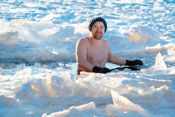 Winter swimming. Brave man in an ice-hole