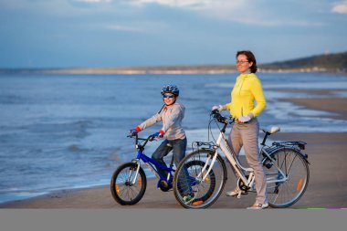 Genç Anne ile küçük oğlu sahilde bisiklet sürme