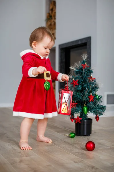 Adorable little girl holding Christmas lantern at home. Decorated Christmas tree — Stock Photo, Image