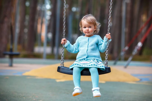 Çok güzel bebek kız yaz gününde bir salıncak üzerinde eğleniyor