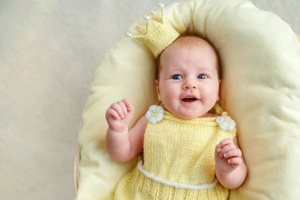 黄金の王冠と黄色のボディー スーツのバスケットで横になっている新生児女の子の肖像画 — ストック写真