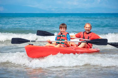 Baba ve oğul okyanusta Kayak. Genç çocuk ile aktif bir tatil. Tatil etkinliği öğrenci çocuk ile
