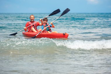 Baba ve oğul okyanusta Kayak. Genç çocuk ile aktif bir tatil. Tatil etkinliği öğrenci çocuk ile