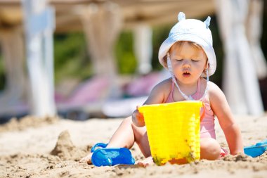 Tropik sahilde oynayan çocuk. Küçük kız kazma kum deniz desteklemek. Çocuklar kum oyuncaklarla oynar. Küçük çocuklarla seyahat