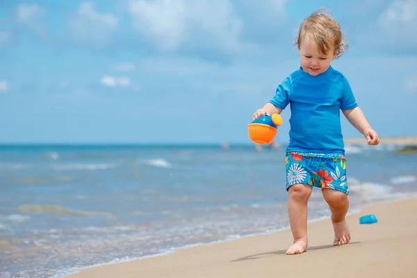 Urocza dziewczynka malucha grając na piaszczystej plaży — Zdjęcie stockowe