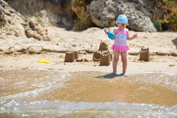 Bedårande liten flicka bygga sandslott på stranden — Stockfoto