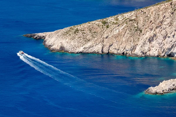 A rental boat move around the cliff, Zakynthos, Greece