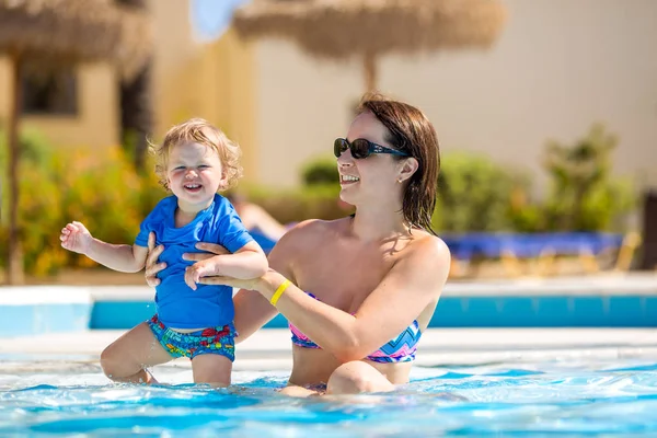 Mother and baby in swimming pool. Parent and child swim in a tropical resort. Summer outdoor activity for family with kids — Stock Photo, Image