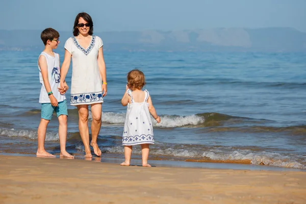 열 대 해변 휴가에 그녀의 두 아이 들과 젊은 어머니 — 스톡 사진