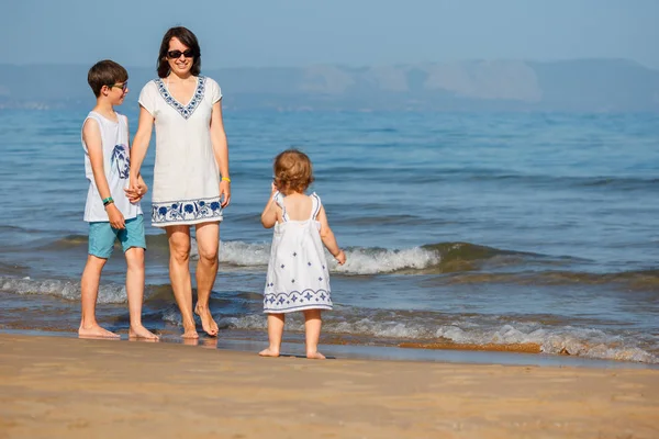 Ung mamma med sina två barn på tropisk strandsemester — Stockfoto