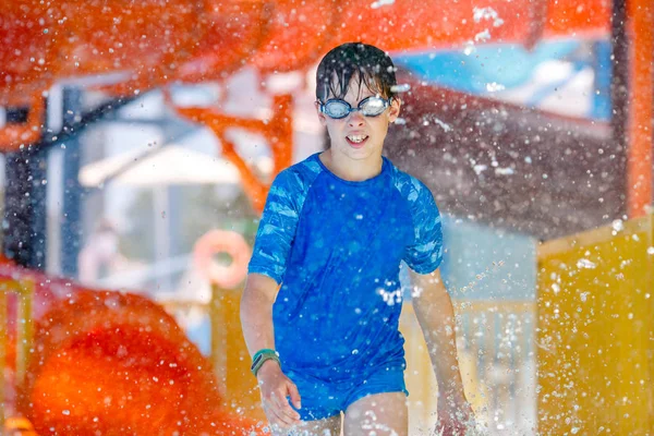 Outdoor portrait of young smiling child having fun in aquapark. Enjoying day trip to an aqua amusement park — Stock Photo, Image