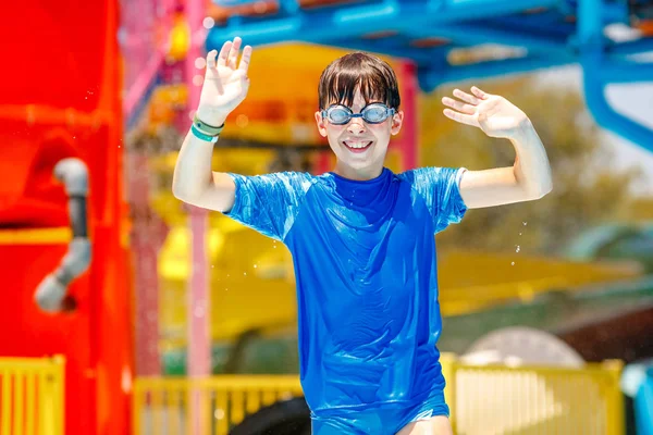 Outdoor portrait of young smiling child having fun in aquapark. Enjoying day trip to an aqua amusement park — Stock Photo, Image