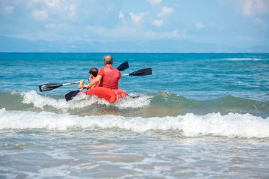 Baba ve oğul okyanusta Kayak. Genç çocuk ile aktif bir tatil. Tatil etkinliği öğrenci çocuk ile
