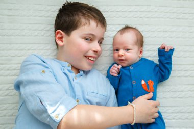 Big brother onun yeni doğan bebek kız sarılma. Yürümeye başlayan çocuk toplantı n