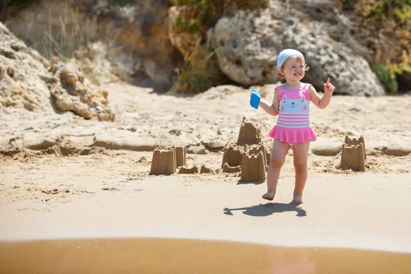 Adorable niña construyendo castillos de arena en la playa —  Fotos de Stock