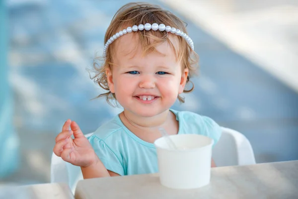 Adorável menina comendo sorvete no café ao ar livre — Fotografia de Stock