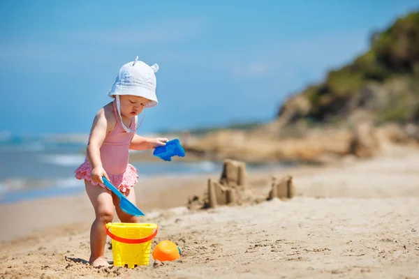 Dziecko gry na tropikalnej plaży. Mała dziewczynka kopania piasku i budować zamek z piasku na morzu brzegu. Dzieci bawić się zabawkami piasek. Podróż z dziećmi — Zdjęcie stockowe