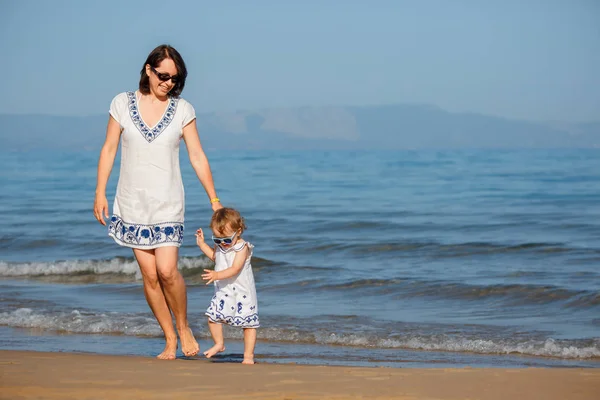 Mladá matka a její roztomilý miminko holčička běh a hraje na krásné tropické pláže — Stock fotografie