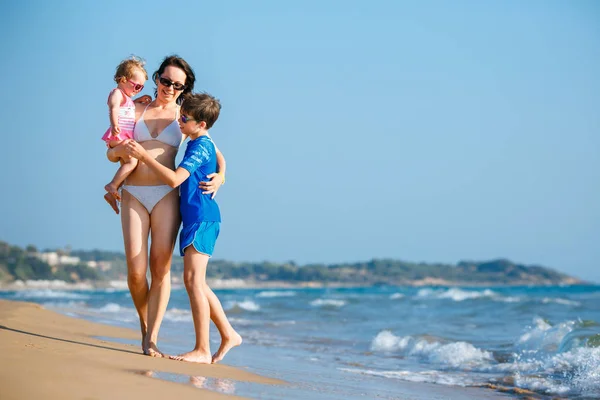 熱帯のビーチでの休暇に彼女の 2 人の子供を持つ若い母親 — ストック写真