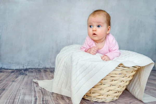 Porträt eines niedlichen Neugeborenen, das auf dem Bauch in einem Holzkorb liegt — Stockfoto