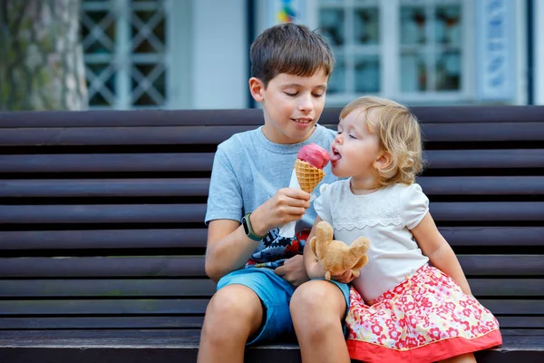 Big brother giving his ice cream to little sister outdoor - Stock Photo, Im...