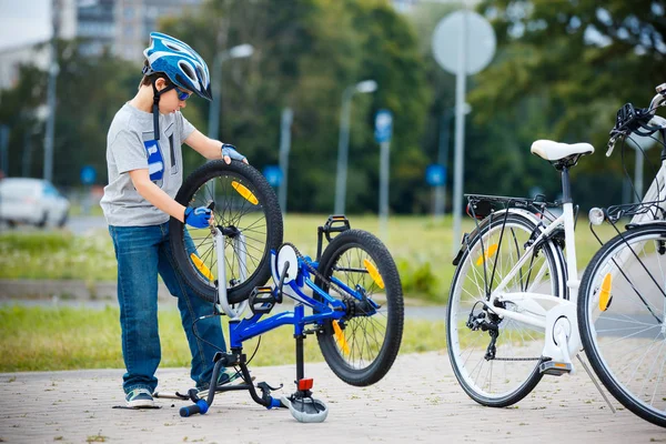 Carino bambino che ripara la sua bicicletta all'aperto — Foto Stock