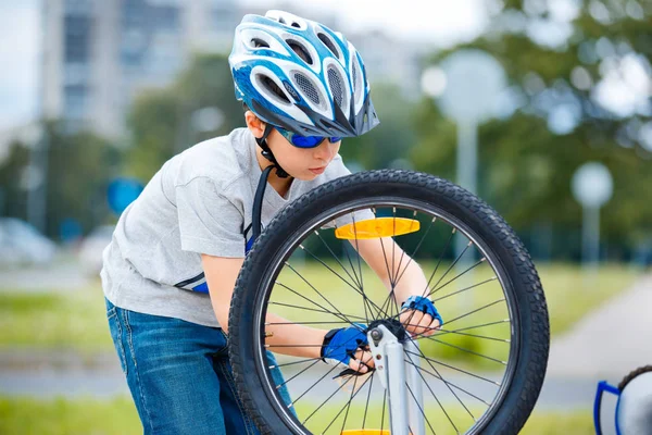 Carino bambino che ripara la sua bicicletta all'aperto — Foto Stock