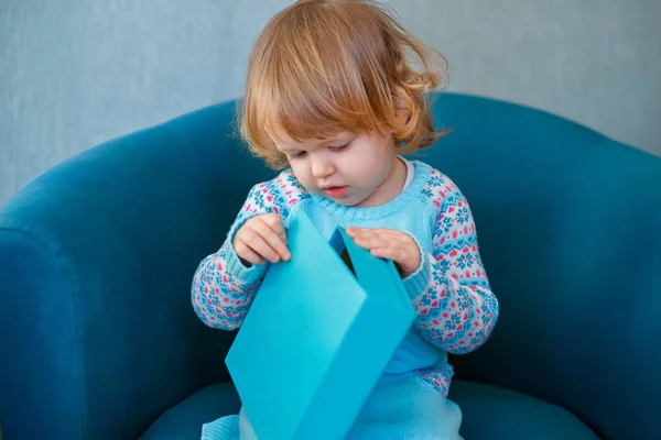 Adorable petite fille qui fête son deuxième anniversaire. Petit enfant ouverture cadeaux Image En Vente