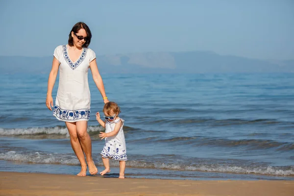 Giovane madre e la sua bambina carina correre e giocare su una bella spiaggia tropicale Foto Stock Royalty Free