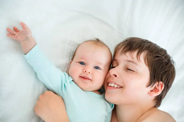 Schattige jongen en pasgeboren baby meisje. Peuter Kid knuffelen zijn broer/zus. — Stockfoto