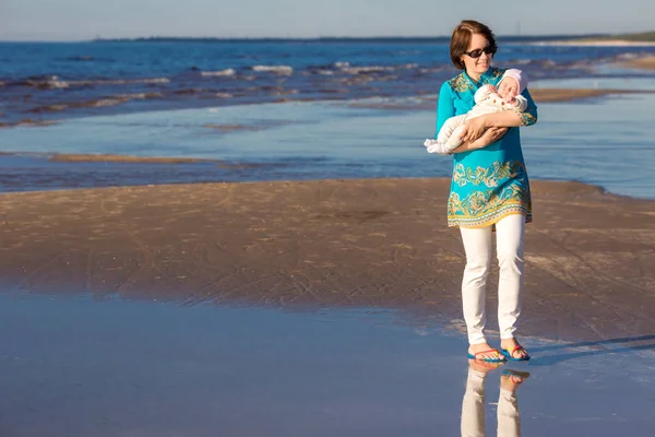 Fiatal anya és az ő aranyos kislány játszik egy gyönyörű nyári strandon — Stock Fotó