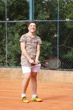 Tenis Kortu üzerinde genç çocuk kalmak 