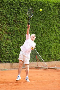 Modern yaşlı adam maçta topu servis