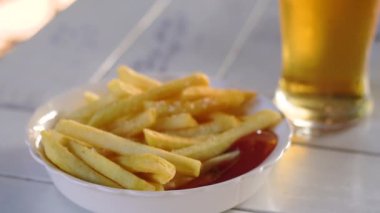 Ketçap ve bir bardak bira ile patates kızartması