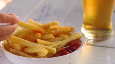 Ketçap ve bir bardak bira ile patates kızartması
