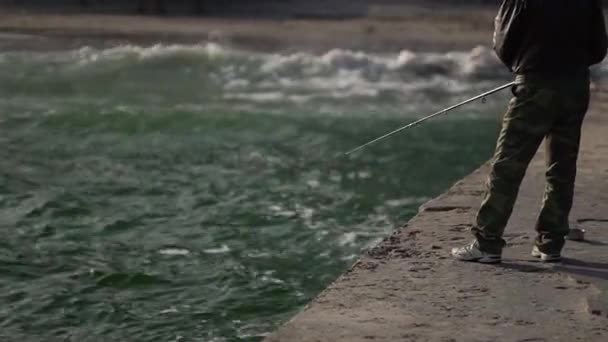 Mann fängt Fische auf der Seebrücke am Meer. — Stockvideo