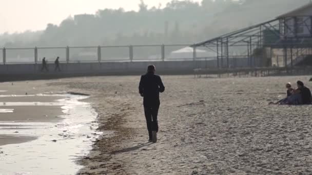 Mannen springer längs havsstranden. Sportaktiviteter på kusten. — Stockvideo