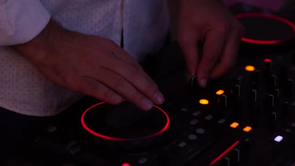 DJ bepaalt de console van de muziek in een nachtclub. — Stockvideo