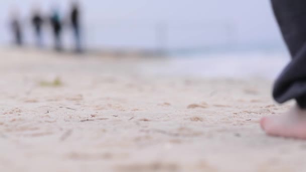 Un adolescente cammina a piedi nudi lungo la spiaggia. — Video Stock