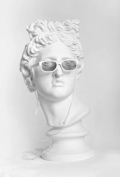 아폴로 머리의 동상입니다 동상입니다 이어폰과 선글라스에 아폴로 머리의 석으십시오 — 스톡 사진