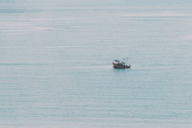 Soyut, en az, gerçeküstü arka plan - küçük tekne sessizce deniz suyu içinde yola çıkacak. İnstagram tarzı yumuşak sinematik renklerde tonda.