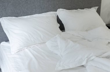 Ayrıntılı olarak yatak odası, bir boş yatak, beyaz yastık ve battaniye yakın çekim, yatak takımları, sabah acele acele buruşuk.