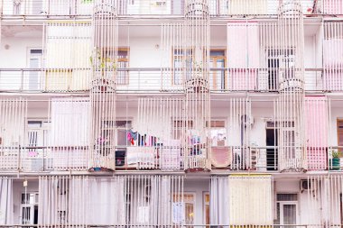 Cephe daire ev, bambu gövdeleri, clothesline üzerinde asılı giysi kurutma ile dekore edilmiş. Arka plan soluk şehir günlük yaşam. Pembe pastel renklerle tonda. Batum, Gürcistan