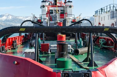 Georgia, bayrak karla kaplı Dağları'nın arka planda ile arkadan görünüm teknenin demir güverte tug. Batum.