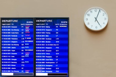 Havaalanı bilgi yönetim kurulu, eliyle saatin beş, uçuş programı son dört dakika gösterir. Malezya, Kuala Lumpur, KLIA 2.