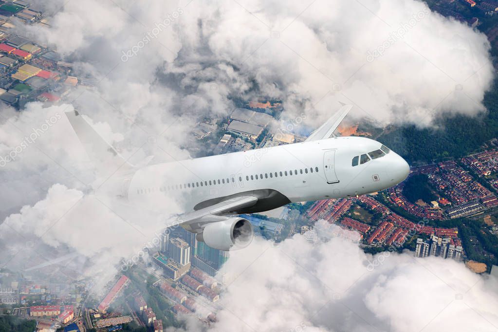 Plane flying sky. Airplane above city. White passenger aircraft climbs through the clouds. Planes and cities. Transportation and travel. Malaysia.