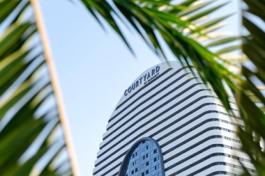 Courtyard Marriott işareti, palmiye yaprakları tarafından çevrili tarafından.  