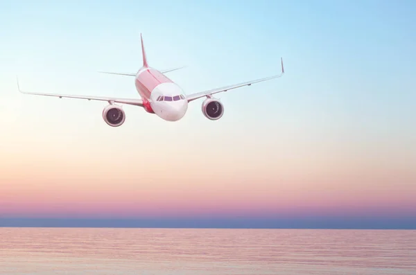 Plane flying in the sky, summer travel flight, airplane over water